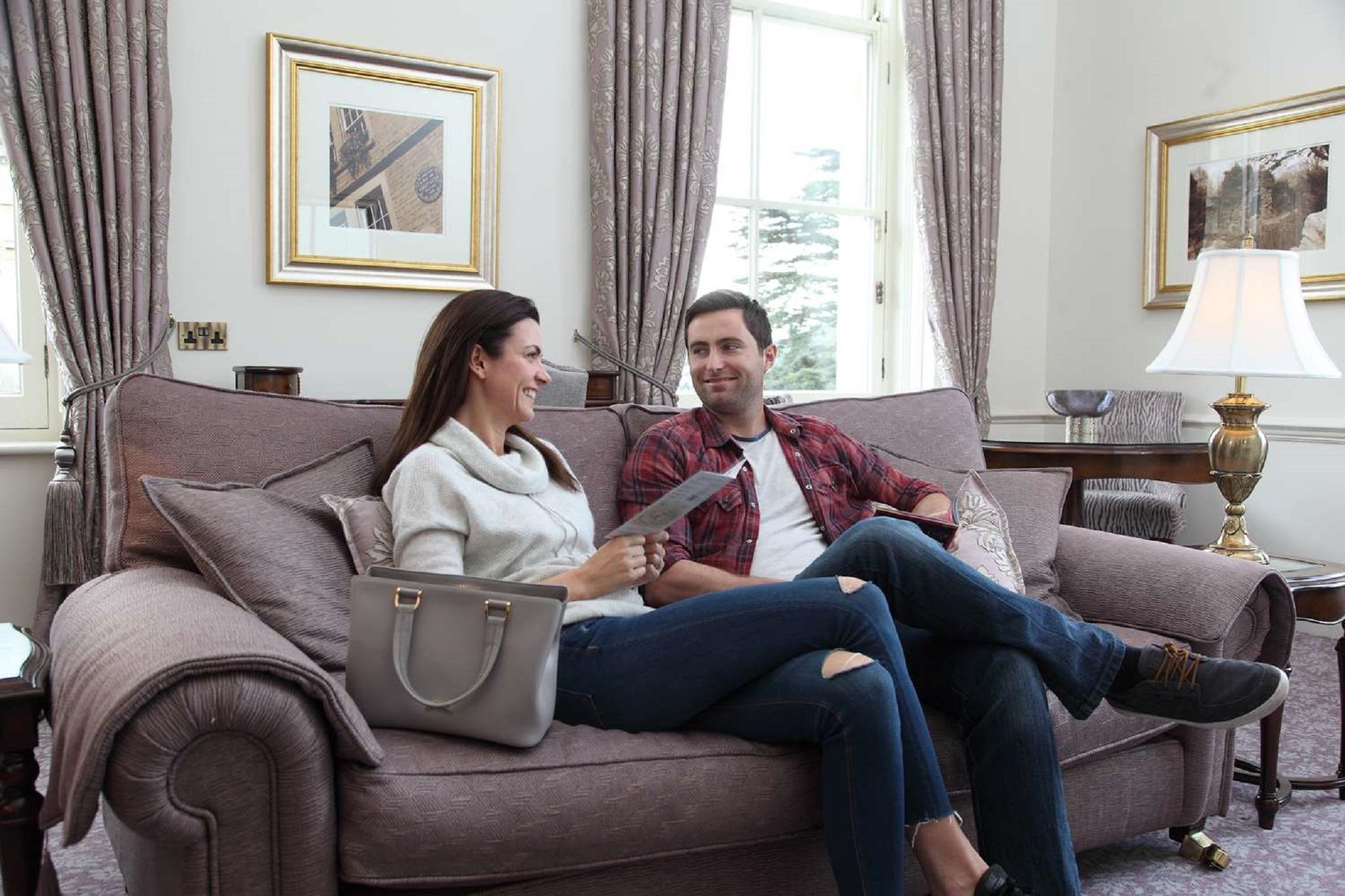 Macdonald Bath Spa Hotel Eksteriør bilde The photo shows a man and a woman sitting together on a comfortable sofa in a well-decorated room. The woman is holding a piece of paper and appears to be engaged in conversation with the man, who is smiling in response. They are both dressed casuall