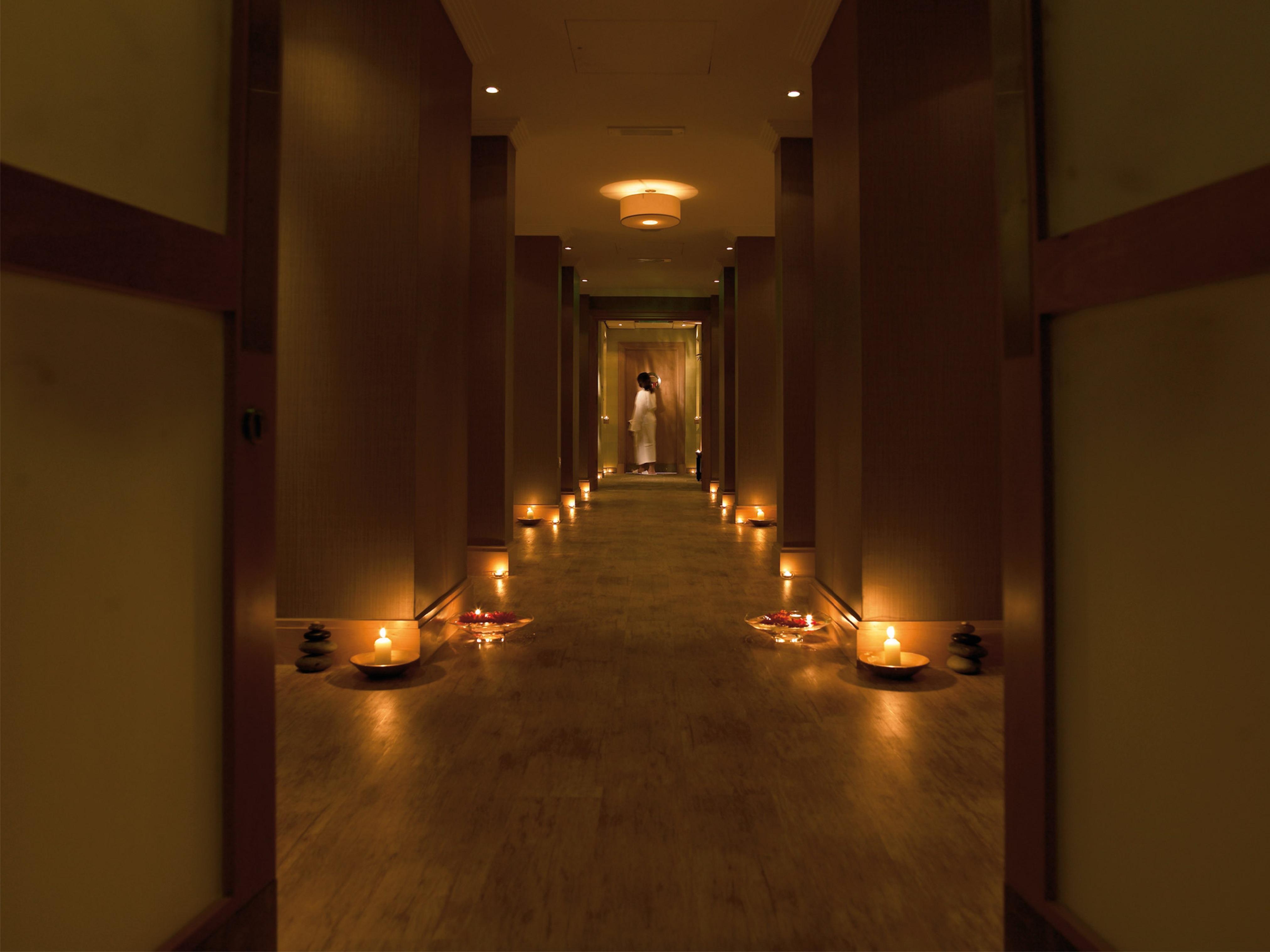 Macdonald Bath Spa Hotel Eksteriør bilde The photo shows a dimly lit corridor lined with soft lighting. On both sides of the hallway, small candles are placed in bowls, creating a warm and inviting ambiance. At the end of the corridor, there appears to be a person standing, possibly prepari