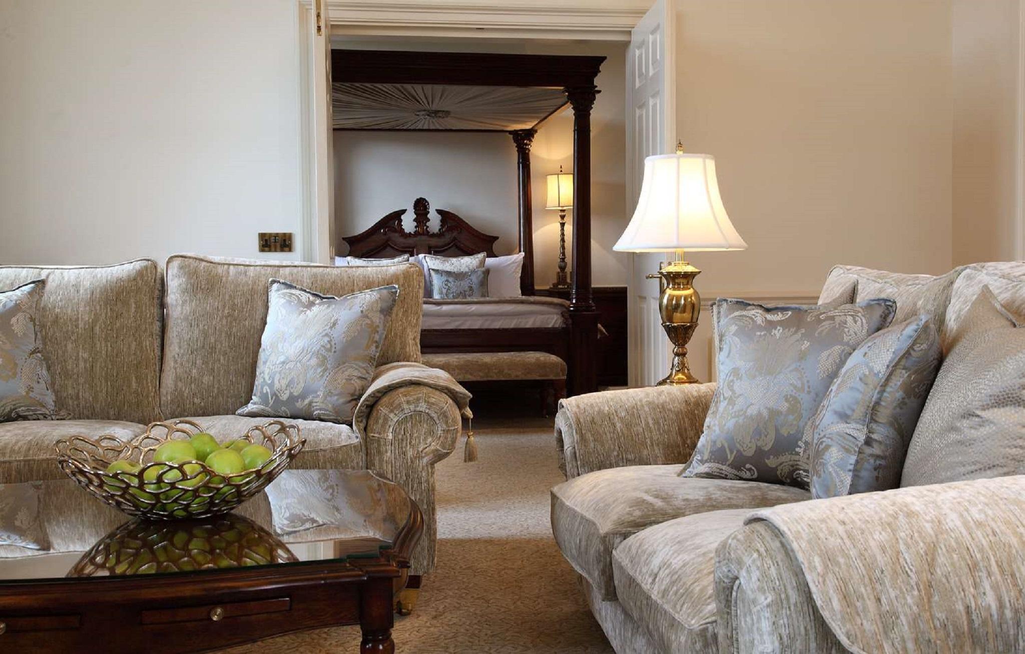 Macdonald Bath Spa Hotel Eksteriør bilde The photo shows a cozy living space with elegant furnishings. On the left, there is a sofa with plush cushions and a stylish armchair, both in a soft, light-colored fabric. In the center, there is a decorative glass table with a bowl containing what 