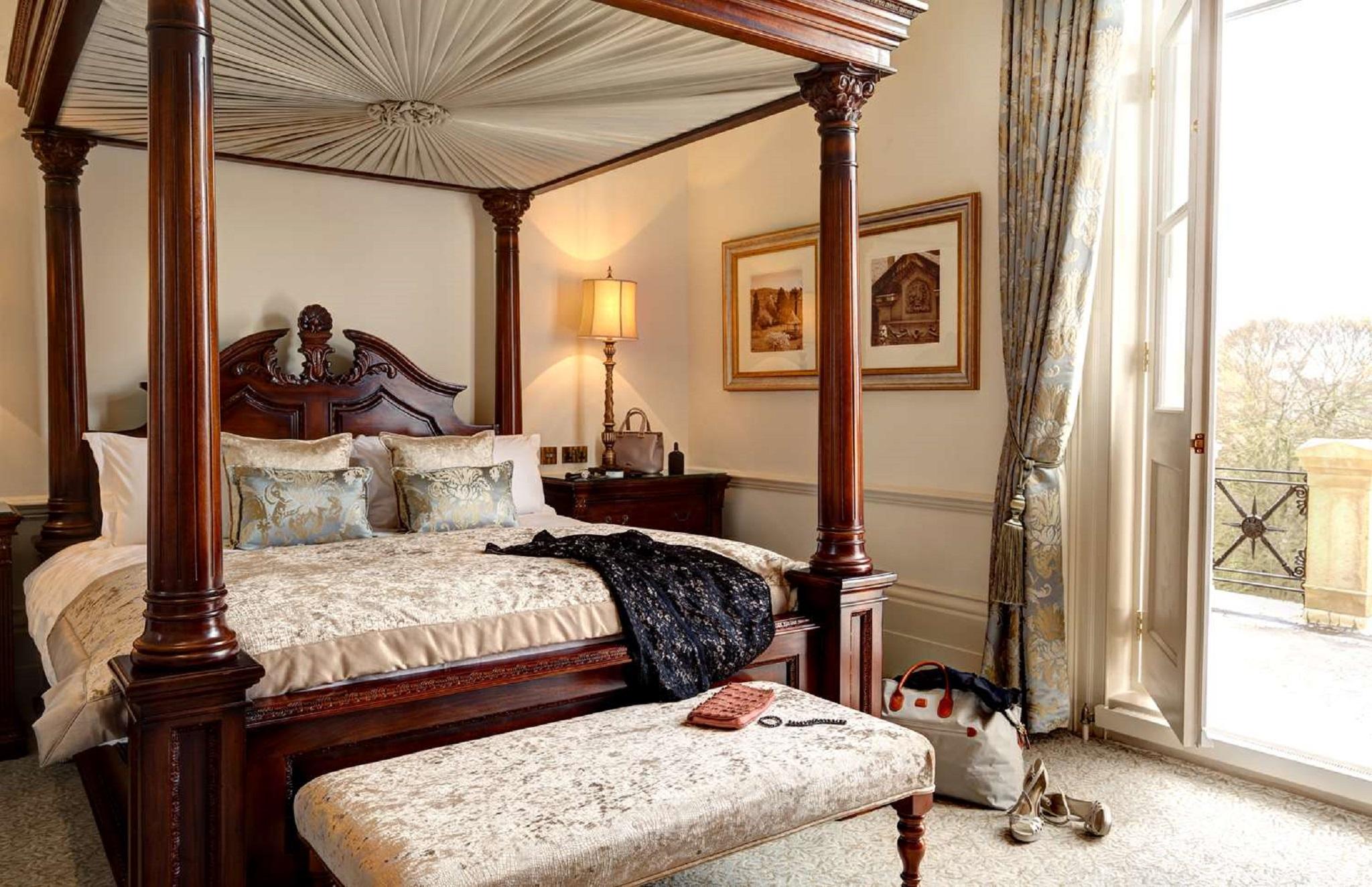 Macdonald Bath Spa Hotel Eksteriør bilde The photo depicts a beautifully designed bedroom featuring a four-poster bed with a decorative canopy. The bed is dressed with elegant bedding and several patterned pillows. Adjacent to the bed, there is a matching wooden nightstand with a stylish la